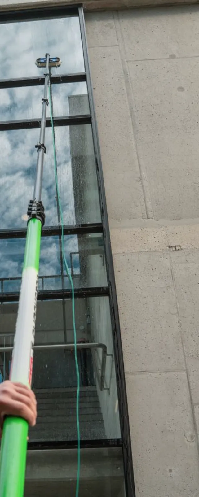 Nettoyage d'une façade vitrée à la perche télescopique alimentée en eau déminéralisée, depuis le sol et sans échafaudage